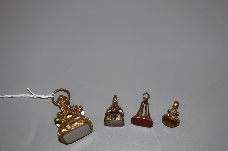 Four assorted 19th century gold plated and gem or hardstone set fob seals, largest 39mm.